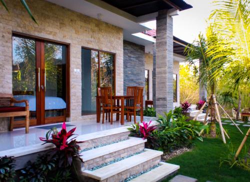 a house with a patio with a table and chairs at Pier26 Bali Homestay in Nusa Dua