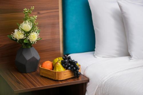 a tray of fruit on a table next to a bed at golden time hostel in Hanoi