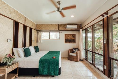 a bedroom with a bed and a ceiling fan at Sinalei Reef Resort & Spa in Maninoa
