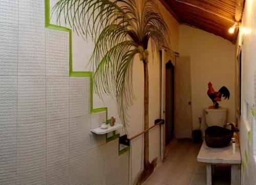 a bathroom with a palm plant on the wall at Uma Nandhi Ubud Natural Cottage in Tegalalang