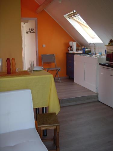 a kitchen with a table with a yellow table cloth at Ferme Lenfant in Ville-Pommeroeul