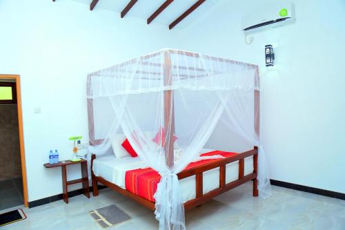 a bedroom with a bed with a canopy at Sigiri Mango Garden Resort in Sigiriya