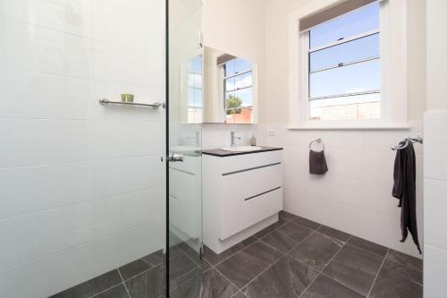 uma casa de banho com um chuveiro e um lavatório. em Waterstreet Apartment em Albury
