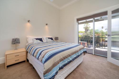 a bedroom with a bed and a large window at Waterstreet Apartment in Albury