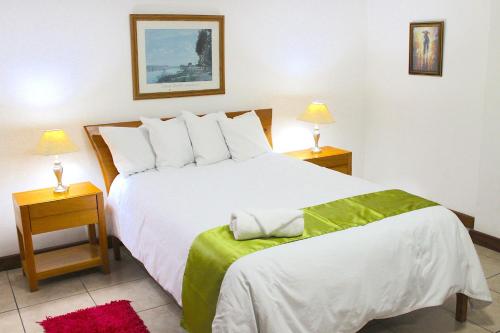 a bedroom with a large white bed with two night stands at Apartamentos Reforma in Guatemala