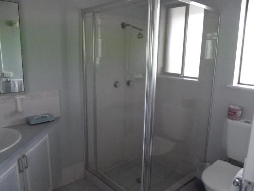 a bathroom with a shower and a toilet and a sink at Bushman's Motor Inn in Lithgow