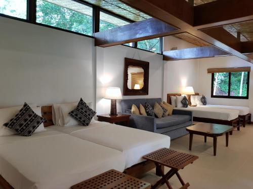 una camera con due letti, un divano e finestre di Casitas de Victoria a Nasugbu