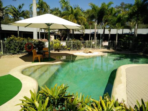 
a patio area with a pool and a lawn chair at Capricorn Motel & Conference Centre in Rockhampton
