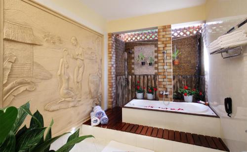 ein Bad mit einer Badewanne und einem Fenster in der Unterkunft Golden Coast Resort & Spa in Phan Thiet