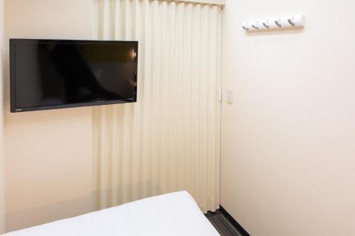 a flat screen tv hanging on a wall at Kuretake Inn Gotemba Inter Gold Cabin in Gotemba