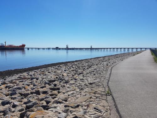 a rocky beach with a pier in the water at Nordseehotel Wilhelmshaven in Wilhelmshaven