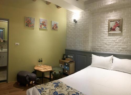 um quarto com uma cama e uma parede de tijolos em Luck Homestay em Jiufen