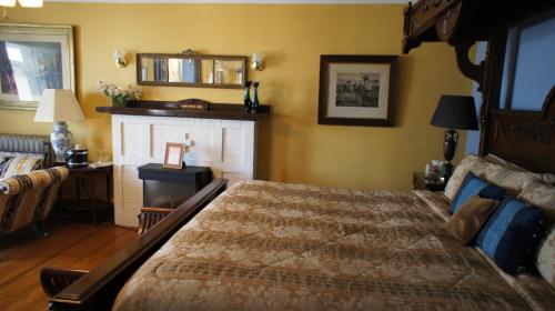 a bedroom with a large bed and a fireplace at A Night to Remember B & B in Niagara Falls