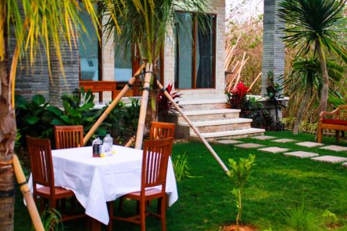 a table with a white table cloth on a yard at Pier26 Bali Homestay in Nusa Dua