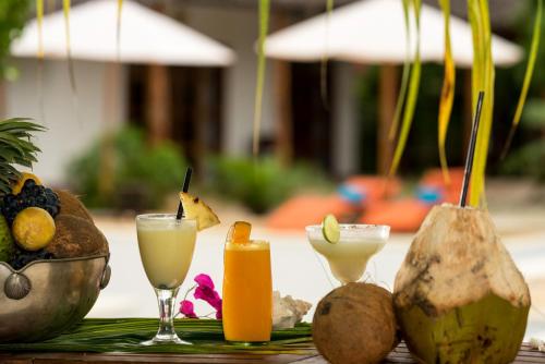 a table with two glasses of juice and some fruit at Tikitam Palms Boutique Hotel in Pongwe