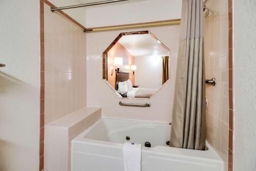 La salle de bains est pourvue d'une baignoire et d'un miroir. dans l'établissement Motel 6-Marion, IL, à Marion