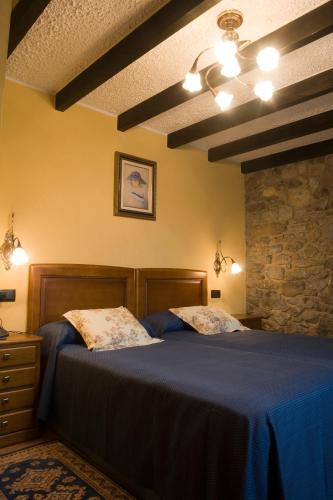 a bedroom with two beds and a stone wall at El Foyu in Colunga