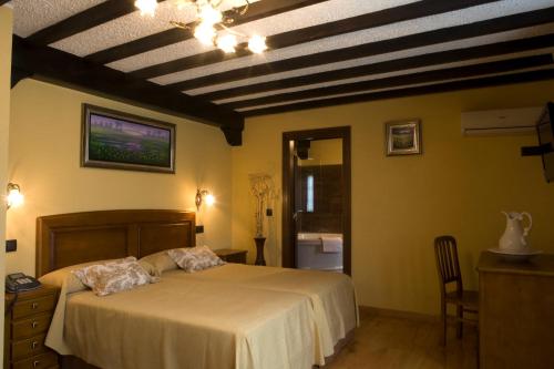 a bedroom with a bed and a ceiling with beams at El Foyu in Colunga
