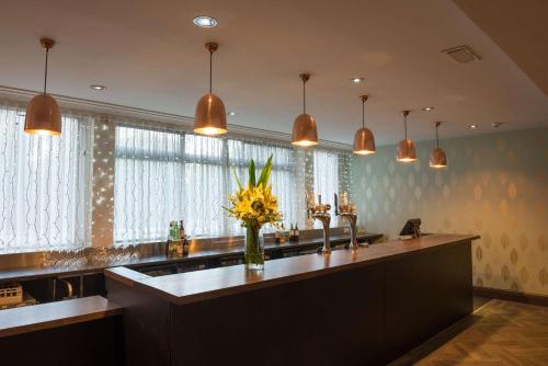 a kitchen with a counter with a vase of flowers at The Lincoln Hotel in Lincoln