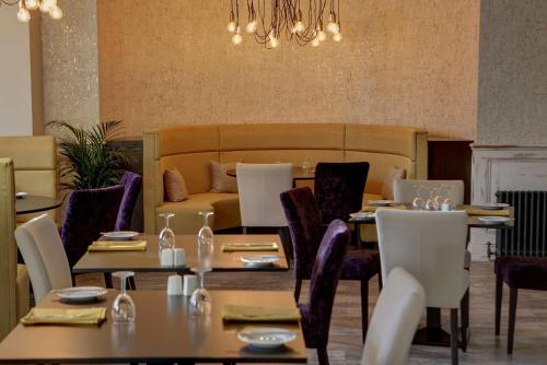 a dining room with tables and chairs and a couch at Burlington Hotel, BW Premier Collection by Best Western in Folkestone