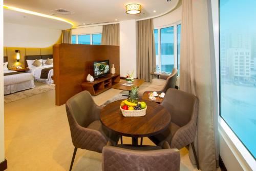 a room with a table and chairs in a hotel room at Arch Hotel in Manama