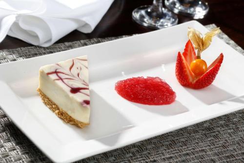 a white plate with a piece of cake and strawberries at Best Western Plus Dunfermline Crossford Keavil House Hotel in Dunfermline