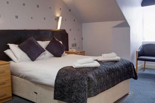 a bedroom with a bed with two towels on it at Woodlands Hotel, BW Signature Collection in Dundee