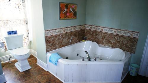 a bathroom with a bath tub and a toilet at A Night to Remember B & B in Niagara Falls