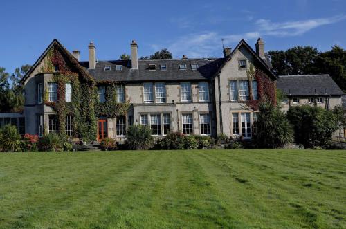 a large house with a large lawn in front of it at Best Western Balgeddie House Hotel in Glenrothes