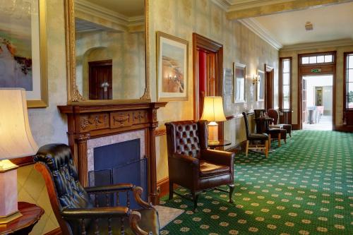 a waiting room with chairs and a fireplace at Best Western Balgeddie House Hotel in Glenrothes