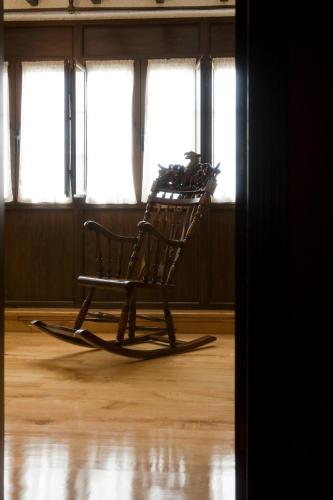 a rocking chair sitting in a room with windows at El Foyu in Colunga
