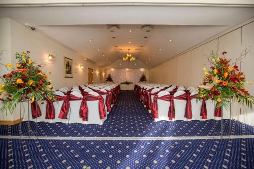 a room with a set up for a wedding with red and white chairs at Best Western Plus Bentley Hotel in Lincoln