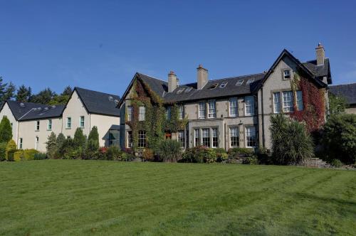 a large house with a large lawn in front of it at Best Western Balgeddie House Hotel in Glenrothes
