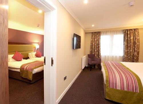 a hotel room with two beds and a window at Woodlands Hotel, BW Signature Collection in Dundee