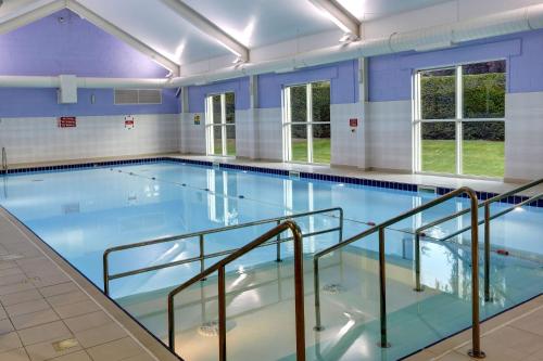 a swimming pool with a blue tub and a blue chair at Best Western Balgeddie House Hotel in Glenrothes