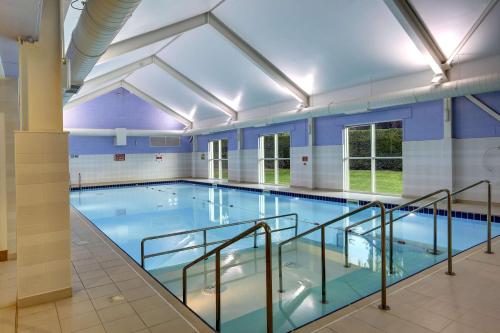 a large indoor swimming pool with blue water at Best Western Balgeddie House Hotel in Glenrothes