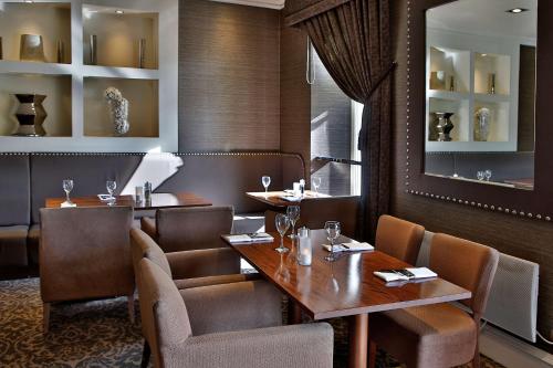 a restaurant with tables and chairs and a mirror at Best Western Motherwell Centre Moorings Hotel in Motherwell