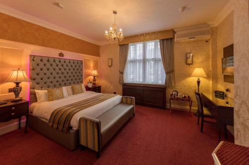 a hotel room with a large bed and a window at Rogerthorpe Manor Hotel in Pontefract