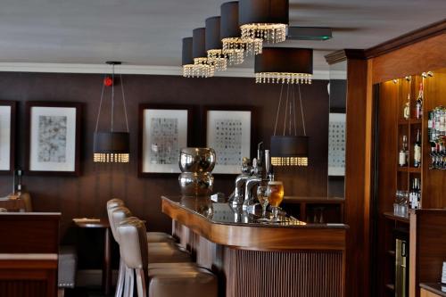 a bar in a restaurant with chairs and chandeliers at Best Western Motherwell Centre Moorings Hotel in Motherwell