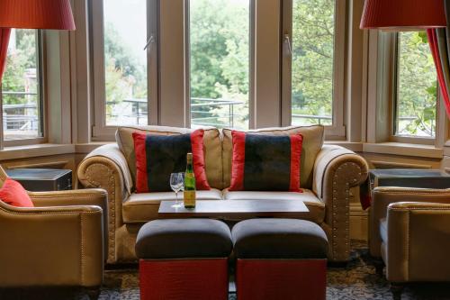 a living room with couches and a table and windows at Best Western Garfield House Hotel in Chryston