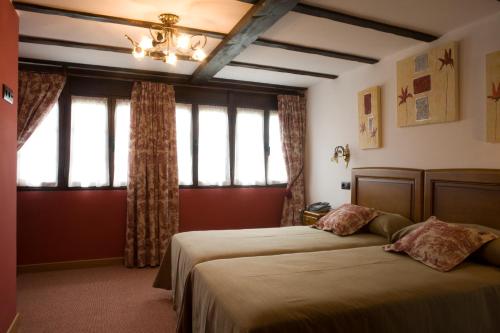 a bedroom with two beds and a window at El Foyu in Colunga