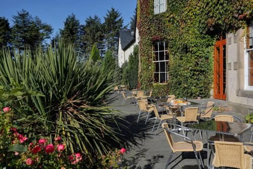 an outdoor patio with tables and chairs and plants at Best Western Balgeddie House Hotel in Glenrothes