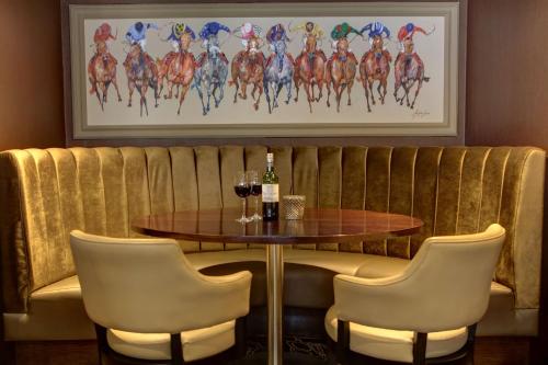 a table with two glasses of wine and two chairs at Best Western Heath Court Hotel in Newmarket