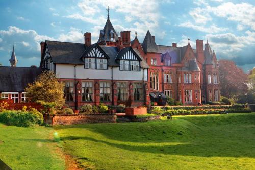 a large house with a green lawn in front of it at Bestwood Lodge Hotel in Nottingham