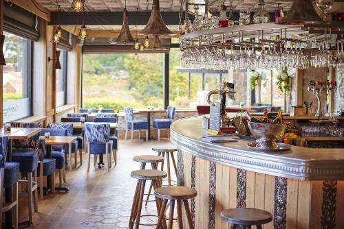 a bar in a restaurant with blue chairs and tables at Best Western Hotel de Havelet in St Peter Port