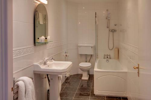 a bathroom with a sink and a toilet and a tub at Bestwood Lodge Hotel in Nottingham