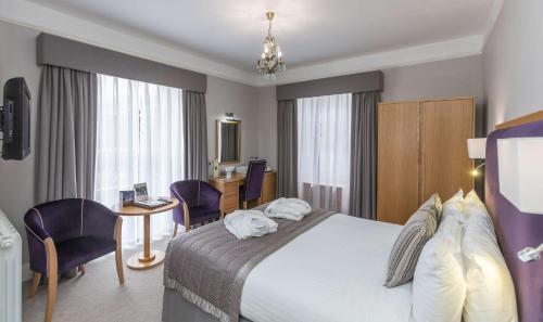 a hotel room with a large bed and a desk at Best Western Hotel de Havelet in St Peter Port