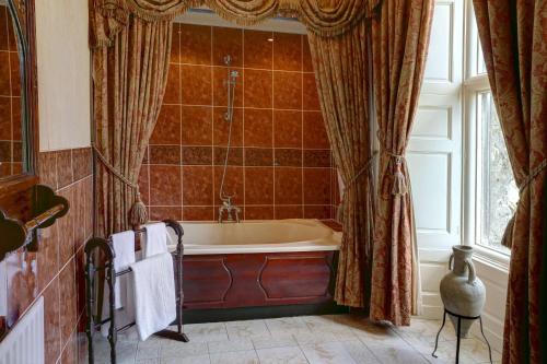 a bathroom with a tub and a window at Walworth Castle Hotel, BW Signature Collection in Darlington