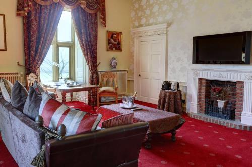 a living room with a couch and a fireplace at Walworth Castle Hotel, BW Signature Collection in Darlington