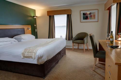 a hotel room with a bed and a desk and chair at Burn Hall Hotel in Huby